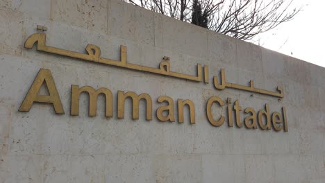 Cartel-De-Bienvenida-De-La-Ciudadela-De-Amman-A-Las-Ruinas-Turísticas-Históricas-Y-Populares-En-La-Ciudad-Capital-De-Jordania,-Escrito-En-Inglés-Y-árabe