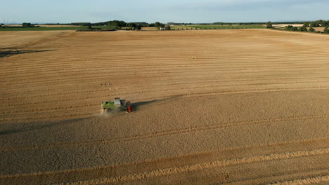 Establishing-Drone-Shot-Slowly-Rotating-Around-Claas-Combine-Harvester-Harvesting-at-Golden-Hour-UK