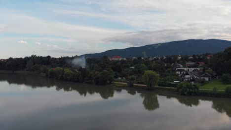 Langsamer-Flug-Neben-Etwas-Rauch-In-Der-Nähe-Von-Häusern-über-Der-Drau-Bei-Maribor
