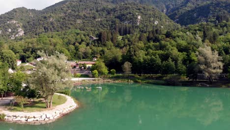 Vuelo-De-Drones-Hacia-Un-Pequeño-Bote-En-El-Lago-Barcis-En-Los-Dolomitas-Del-Norte-De-Italia
