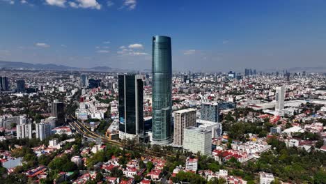 Mítikah-Tower-is-a-mixed-use-office-and-residential-tower,-in-sunny-Benito-Juarez,-Mexico---Orbit,-aerial-view