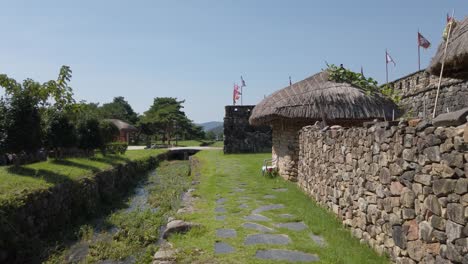 Walking-along-stone-wall,-Naganeupseong-Folk-Village-Suncheon,-South-Korea