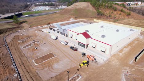 órbita-Aérea-Estrecha-De-Una-Tienda-De-Suministro-De-Tractores-Recién-Construida-En-Pelham,-Alabama,-Con-Equipo-En-Movimiento