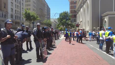 A-line-of-police-in-tactical-riot-gear-keep-watch-over-a-protest-against-Eskom's-load-shedding-and-rolling-blackouts