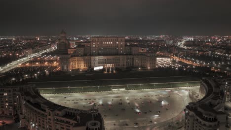Aerial-hyperlapse-of-Romanian-parliament-in-Bucharest-at-night---Cars-driving-on-road---orbit-shot