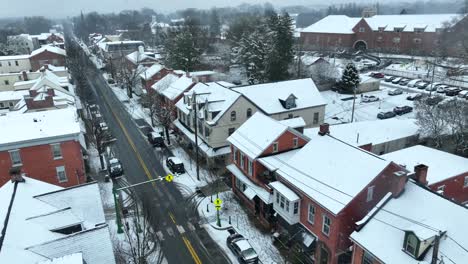 Aerial-view-of-snowflakes-falling-on-quaint-small-town-in-America