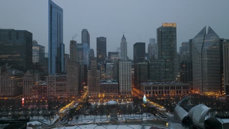 Aerial-view-of-the-Millennium-Park-and-buildings-in-downtown-Chicago,-hazy,-winter-evening-in-Illinois,-USA---panoramic,-drone-shot