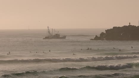 Surf-Matutino-En-La-Playa-De-Duranbah-Mientras-Un-Arrastrero-De-Pesca-Regresa-Del-Océano-Pen,-En-La-Costa-De-Oro-Del-Sur,-Australia,-En-Cámara-Lenta