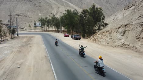 Drei-Motorradfahrer-Fahren-Eine-Bergstraße-Durch-Wüstenberge-Bergab