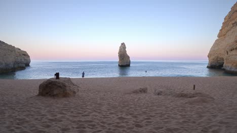 Ein-Einzelner-Fischerangler-An-Einem-Perfekten-Verlassenen-Paradies-Idyllischen-Strand-An-Der-Algarve-Bei-Sonnenaufgang