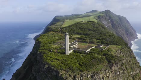 drone-footage-of-a-Lighthouse-on-the-edge-of-dramatic-cliffs-with-the-Atlantic-Ocean-in-the-background,-São-Jorge-island,-the-Azores,-Portugal