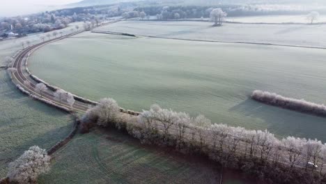 Rotating-aerial-view-of-a-car-driving-on-a-turning-road-in-cold-winter-conditions-in-the-Ardennes,-Belgium