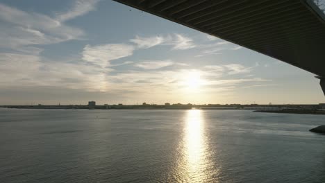 Drone-shot-of-sunset-underneath-bridge,-Ravenel-in-Charleston-SC