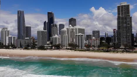 Surfers-Paradise,-Queensland-Australia---February-28-2021:-Aerial-over-the-surf-of-the-Pacific-Ocean-showing-the-high-rise-buildings-of-along-the-Gold-Coast