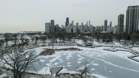 Aerial-view-rising-over-the-Lincoln-Park-Zoo-towards-the-downtown-of-Chicago,-cloudy,-winter-day-in-Illinois,-USA