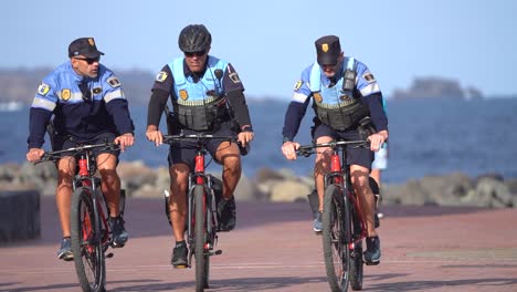 Gran-Canaria,-España---26-De-Enero-De-2023:-Policías-Andando-En-Bicicleta-En-La-Playa-De-Las-Islas-Canarias-En-Gran-Canaria