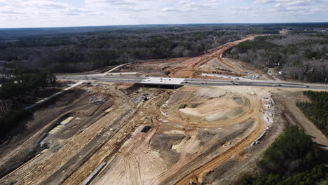 Drone-shot-of-large-highway-construction,-540-Beltline-North-Carolina,-wide-rotating-aerial-shot