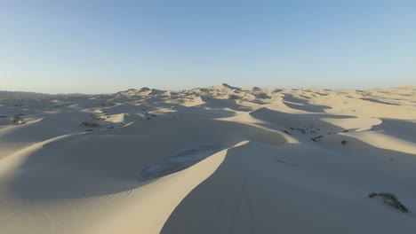 Aerial-panorama-of-a-white-dune-desert-nearly-infinite,-with-a-clear-blue-sky