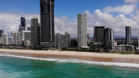 Paraíso-De-Los-Surfistas,-Queensland-Australia---28-De-Febrero-De-2021:-Avance-Aéreo-Sobre-El-Océano-Pacífico-Hasta-La-Playa-Y-Edificios-Altos-De-La-Costa-Dorada