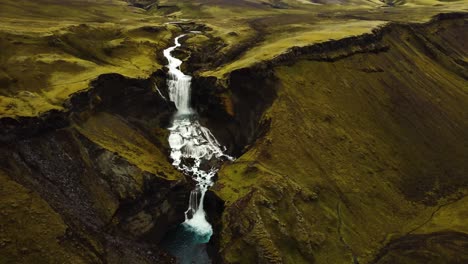 Aerial-panoramic-landscape-view-of-water-flowing-down-Ófærufoss-waterfall,-in-Iceland-highlands