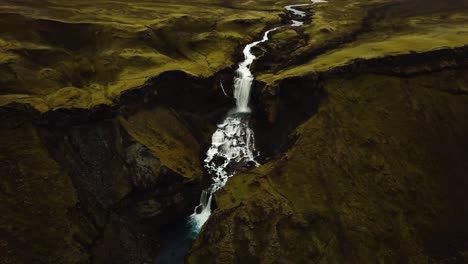 Vista-Panorámica-Aérea-Sobre-El-Agua-Que-Fluye-Por-La-Cascada-Ófærufoss,-En-Las-Tierras-Altas-De-Islandia