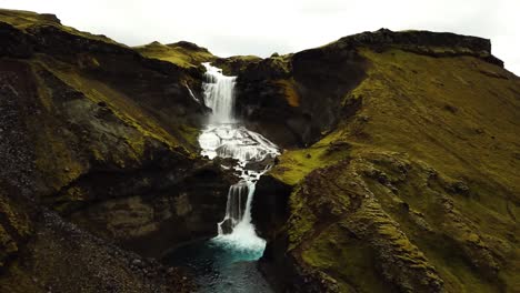 Aerial-landscape-view-of-water-flowing-down-Ófærufoss-waterfall,-in-Iceland-highlands