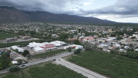 Drone-Aéreo-Sobre-Viñedos-Y-Ciudad-De-Cafayate,-Campo-De-Producción-De-Uva-Escénica-Y-Pueblo-Agrícola-Junto-A-La-Cordillera-Andina,-Salta,-Argentina