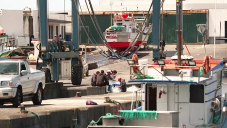Gruppe-Von-Fischern,-Die-Fischernetze-Im-Hafen-Von-Sao-Mateus-Da-Calheta-Auf-Der-Dritten-Insel,-Portugal,-Vorbereiten