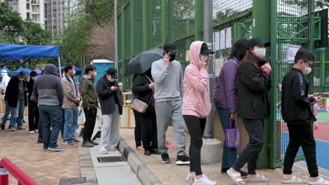 Chinesische-Einwohner-Durchlaufen-Einen-Covid-19-Coronavirus-Massenscreening-Test-Außerhalb-Eines-öffentlichen-Wohngebäudes,-Das-Gesperrt-Wurde,-Nachdem-Eine-Große-Anzahl-Von-Einwohnern-Positiv-Getestet-Wurde