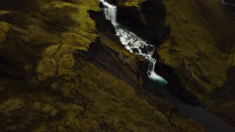 Aerial-drone-view-above-water-flowing-down-Ófærufoss-waterfall,-in-Iceland-highlands