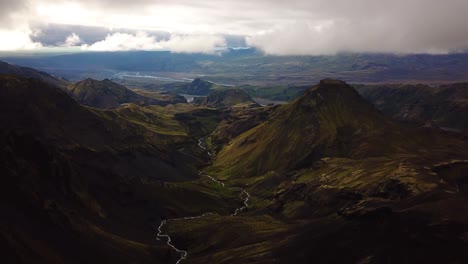 Aerial-landscape-view-over-a-river-flowing-through-a-mountain-valley,-in-Fimmvörðuháls-area,-Iceland