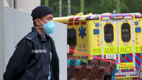 Un-Oficial-De-Policía-Hace-Guardia-Afuera-De-Un-Edificio-De-Vivienda-Pública-Colocado-Bajo-Cierre-Forzado-Después-De-Que-Un-Gran-Número-De-Residentes-Dieron-Positivo-En-El-Coronavirus-Covid-19