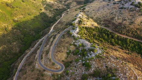 Drone-shot-of-car-on-the-curvy,-mountain,-rural-road-in-Corfu-island,-Greece