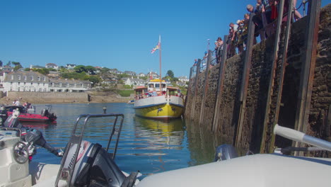 Tourists-Fishing-On-St-Mawes-Port-With-Docked-Ferry-Boat-In-Cornwall,-United-Kingdom