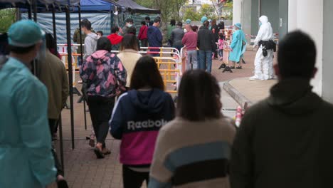 Residents-walk-through-a-Covid-19-Coronavirus-mass-testing-as-a-public-housing-complex-is-placed-under-lockdown-after-a-large-number-of-residents-tested-positive