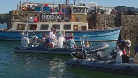 People-Riding-On-Rubber-Boat-Arriving-At-The-Harbour-Of-St-Mawes-In-Cornwall,-UK