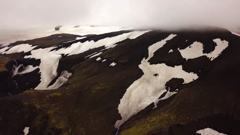 Aerial-landscape-view-of-mountains-with-melting-snow,-on-a-foggy-day,-Fimmvörðuháls-area,-Iceland