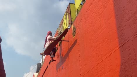 Lokaler-Arbeiter-In-Bangladesch,-Der-Mit-Einem-Winkelgleiter-Arbeitet,-Um-Ein-Containerschiff-Zu-Reparieren