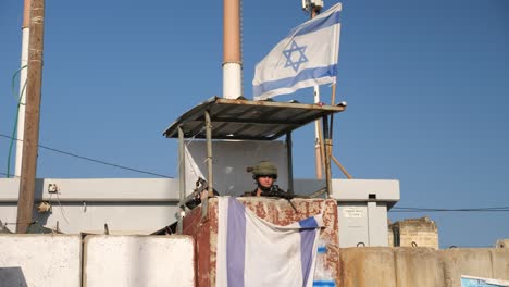 Idf-soldat-Im-Sicherheitsturm-Schwenkt-Die-Israelische-Flagge-Und-Macht-Eine-Kussgeste