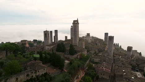 Medieval-Town-Of-San-Gimignano-In-Tuscany,-Italy-On-A-Foggy-Morning---aerial-drone-shot