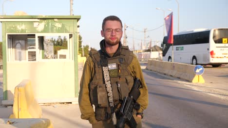 Heavily-armed-Israeli-soldier-walking-confidently-near-security-checkpoint,-Jerusalem