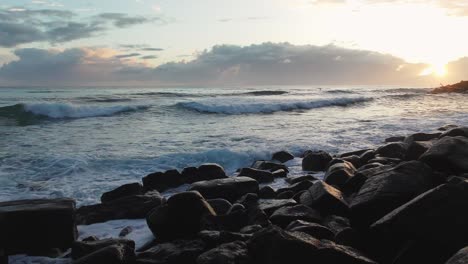 Waves-Hitting-Rocks-at-Coastside-During-Sunrise,-Low-Angle-View