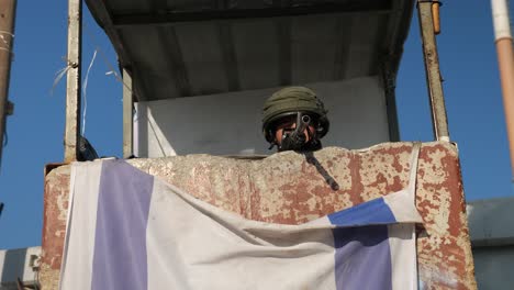 lurking-IDF-soldier-with-sniper-in-rusty-Observation-tower,-arch-shot