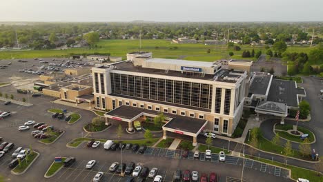 Beaumont-hospital-building-with-logo-on-rooftop,-aerial-fly-away-view