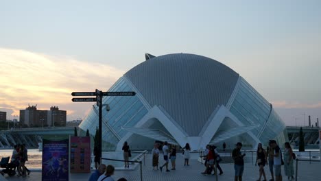 Tourists-at-The-City-of-Arts-and-Sciences,-The-Hemisferic-cinema-in-Valencia,-Spain,-Evening