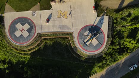 Double-landing-pad-with-single-helicopter-near-Michigan-University-hospital,-aerial-view