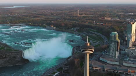 Niagarafälle-Von-Der-Kanadischen-Seite-Mit-Aussichtsturm-Während-Des-Sonnenuntergangs,-Drohne-Absteigend-Und-Umkreisend