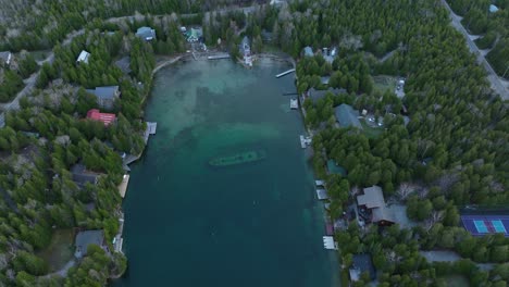 Ship-wreck-at-Bruce-peninsula,-Ontario,-Canada-in-early-spring-and-lake-Huron,-Drone-approaches-the-Ship-and-tilt-up