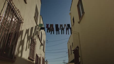 Tiro-Estático-Ancho-De-ángulo-Bajo-De-Ropa-Colgada-En-Un-Alambre-Afuera-Para-Secarse-Bajo-El-Sol-De-California