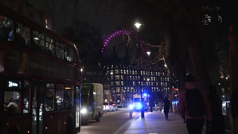 Ambulancia-Pasando-Delante-Del-Ojo-De-Londres-Y-La-Abadía-De-Westminster,-Londres,-Reino-Unido